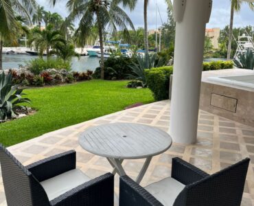 departamento de dos recamaras habitaciones en gran peninsula puerto aventuras jacuzzi con mesa y sillas en terraza con vista al canal y jardin